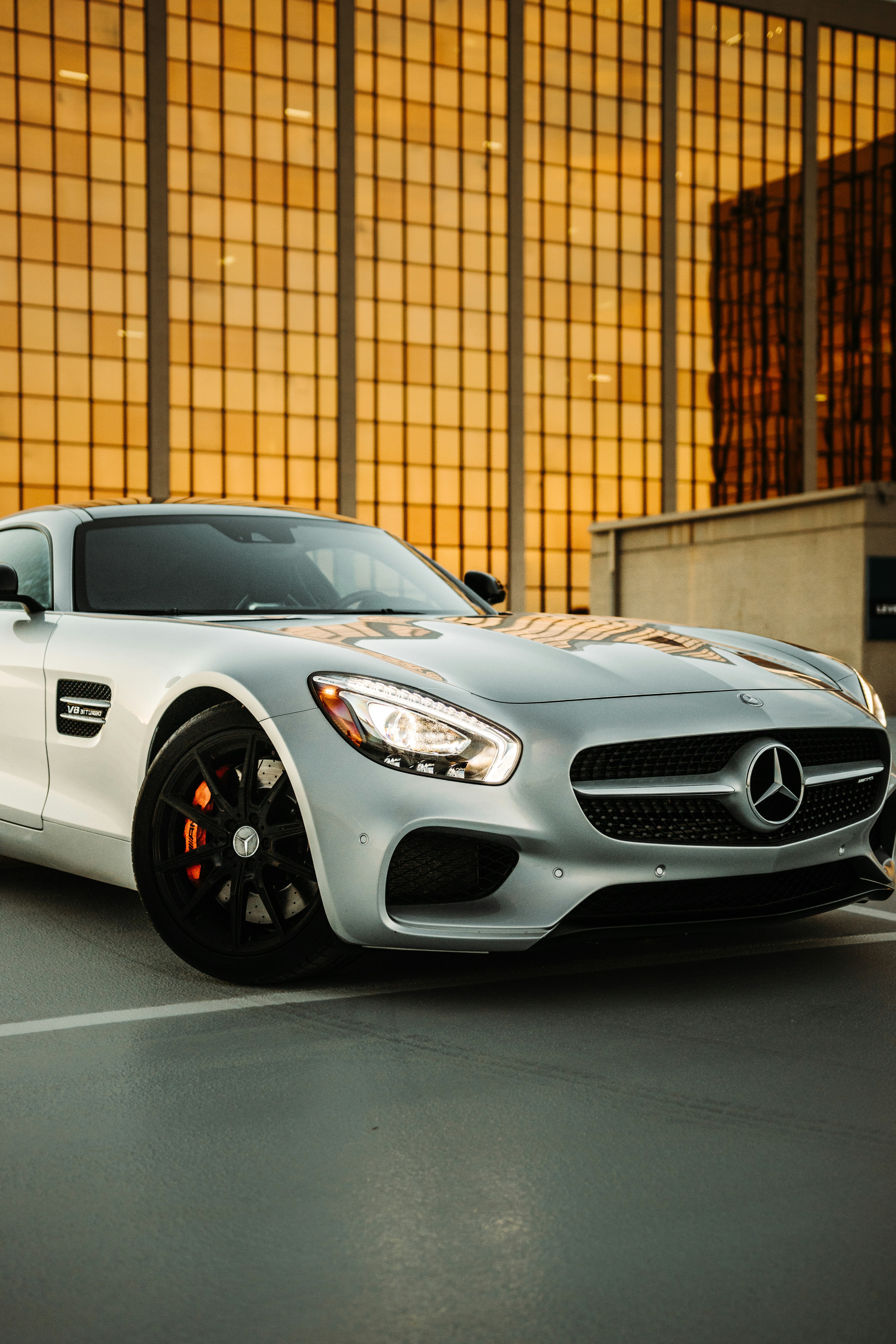 white mercedes benz coupe parked beside brown brick wall